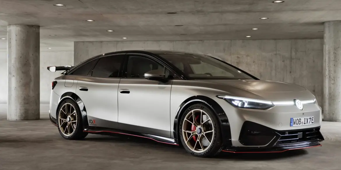 Seitliche Ansicht des Volkswagen ID.X Performance Elektro-Konzeptfahrzeugs in einer Tiefgarage mit markanten Sportfelgen und großem Heckflügel.
