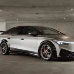 Seitliche Ansicht des Volkswagen ID.X Performance Elektro-Konzeptfahrzeugs in einer Tiefgarage mit markanten Sportfelgen und großem Heckflügel.