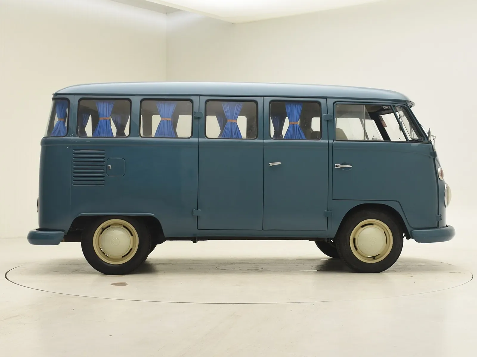 Blauer Volkswagen T1 Bus Baujahr 1974, Seitenansicht im Studio mit blauen Vorhängen an den Fenstern