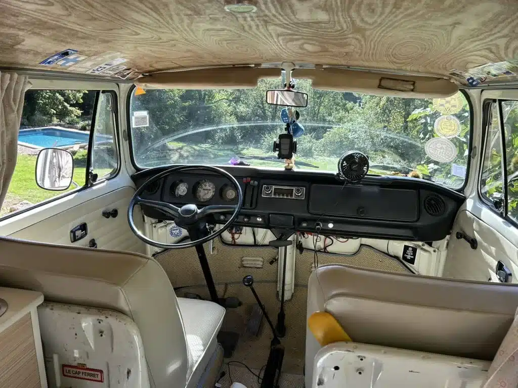 Blick in den restaurierten Innenraum eines Volkswagen T2 Westfalia aus dem Jahr 1971 mit Lenkrad, Cockpit und hellen Sitzen.