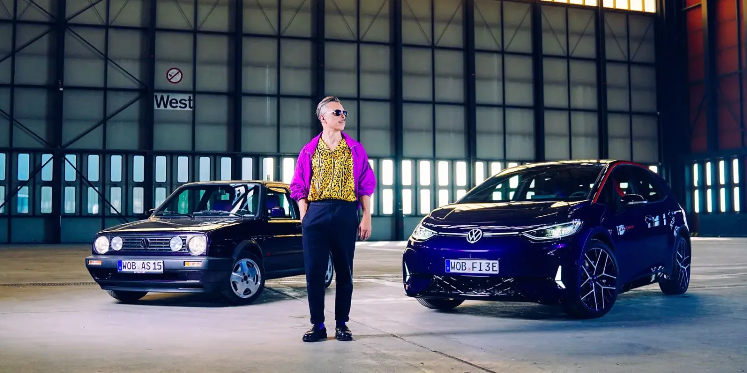 Golf 2 Fire & Ice und VW ID.3 GTX FIRE+ICE gemeinsam in einer Industriehalle mit einer Person dazwischen.