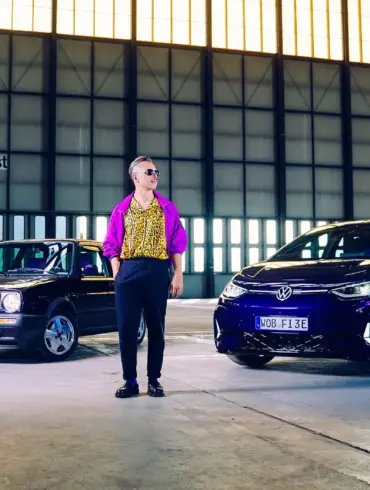 Golf 2 Fire & Ice und VW ID.3 GTX FIRE+ICE gemeinsam in einer Industriehalle mit einer Person dazwischen.