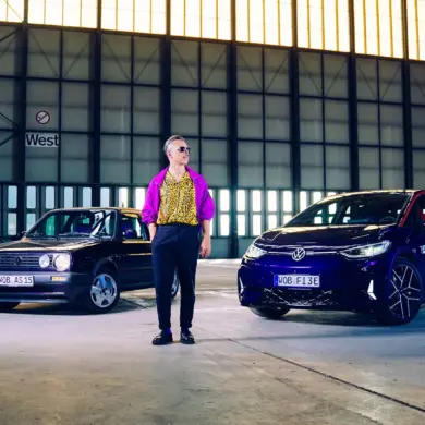 Golf 2 Fire & Ice und VW ID.3 GTX FIRE+ICE gemeinsam in einer Industriehalle mit einer Person dazwischen.