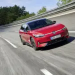 Roter VW ID.7 GTX fährt sportlich auf einer abgesperrten Teststrecke, aufgenommen von vorne seitlich.