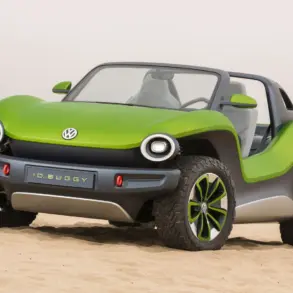Grüner Volkswagen ID. Buggy ohne Dach und Türen steht auf Sand