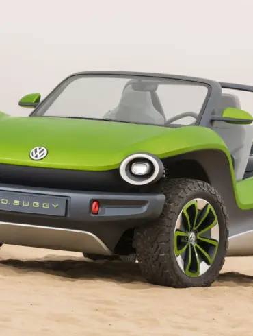 Grüner Volkswagen ID. Buggy ohne Dach und Türen steht auf Sand