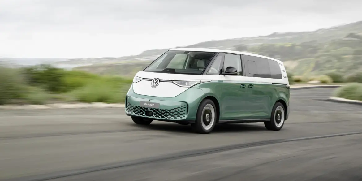 Volkswagen ID. Buzz mit langem Radstand in zweifarbiger Lackierung fährt auf einer Küstenstraße.