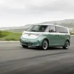 Volkswagen ID. Buzz mit langem Radstand in zweifarbiger Lackierung fährt auf einer Küstenstraße.