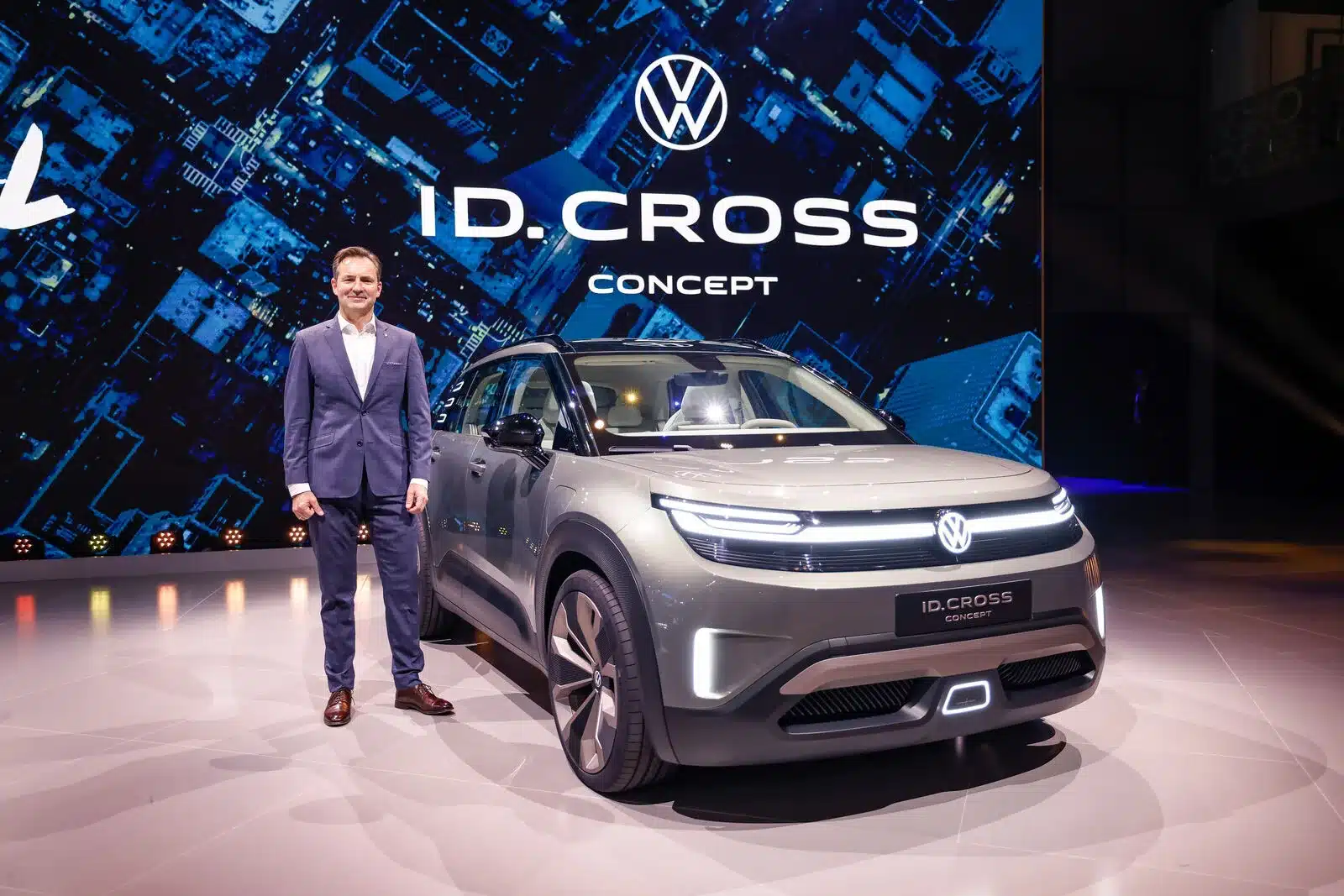 Volkswagen ID. CROSS Concept Elektro-SUV auf einer Messebühne neben einem Mann im Anzug