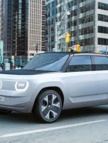 Volkswagen ID. LIFE Konzeptfahrzeug fährt durch eine moderne Innenstadt.