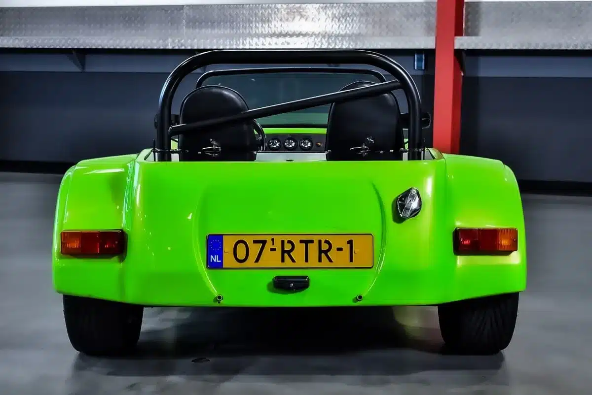 Rückansicht eines lime-grünen Westfield SEi Roadster von 1991, aufgenommen in einer Garage, mit sichtbarem Überrollbügel und niederländischem Kennzeichen.