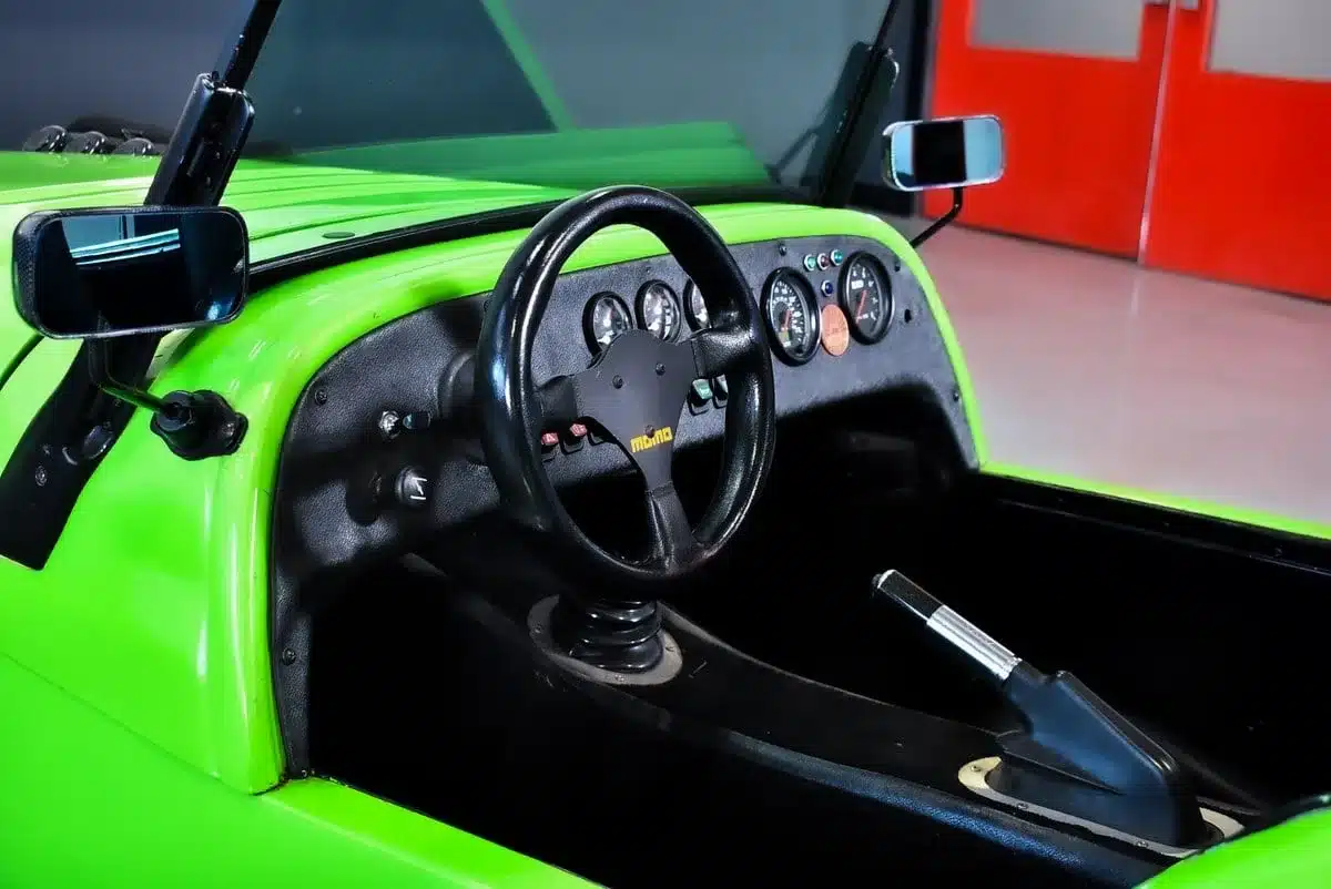 Cockpit des Westfield SEi Roadster von 1991 mit schwarzem Lenkrad, Schalthebel und Armaturenbrett in Lime-Grün.