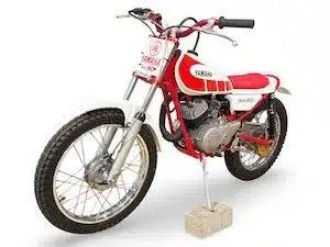 Yamaha TY80 Trial Motorrad mit rotem Rahmen und weiß-rotem Tank, steht auf einem Stein