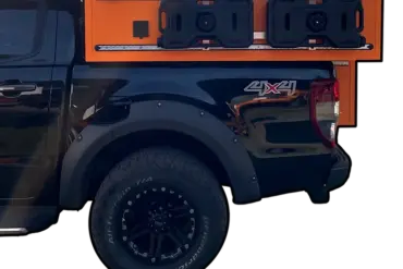 Seitenansicht eines schwarzen Pick-ups mit orangefarbener ZWO.EINZ Wohnkabine, montiert auf der Ladefläche.