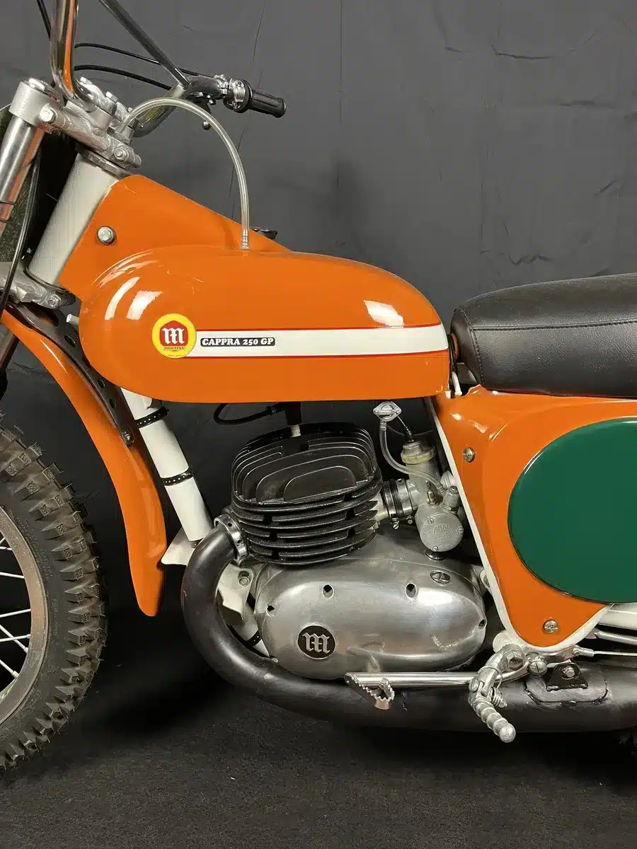 Montesa Cappra 250 GP, Baujahr 1968, vollständig restauriert, orange lackiert, Detailansicht des Motorrads mit Tank, Motor und Sitzbank.