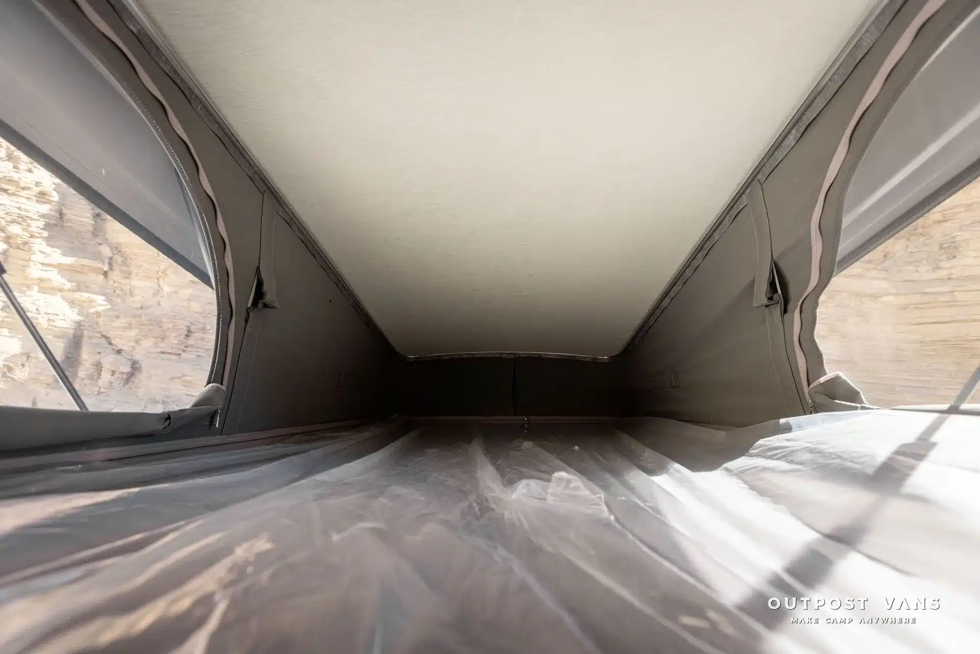 Innenansicht des Schlafbereichs im Aufstelldach eines Mercedes Sprinter PELE Vans mit Fenster und Polsterung