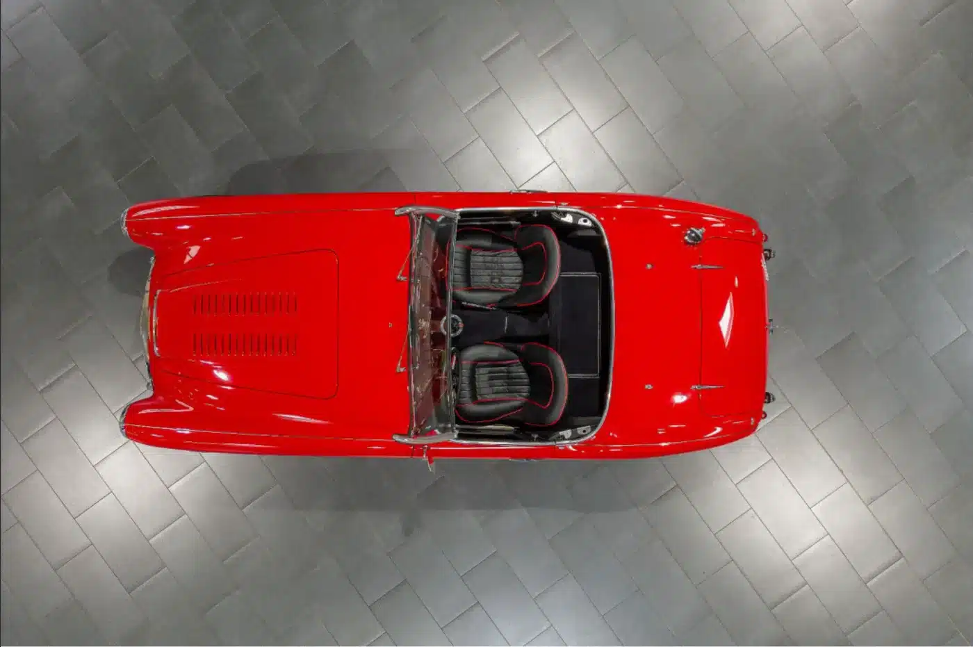 Vogelperspektive eines roten Austin-Healey 3000 MK1 Roadsters, Baujahr 1959, mit geöffnetem Verdeck und schwarzer Innenausstattung