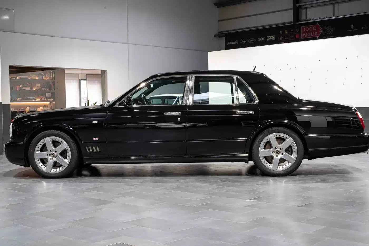 Seitliche Gesamtansicht eines schwarzen Bentley Arnage T24 Mulliner in einer hellen Halle.