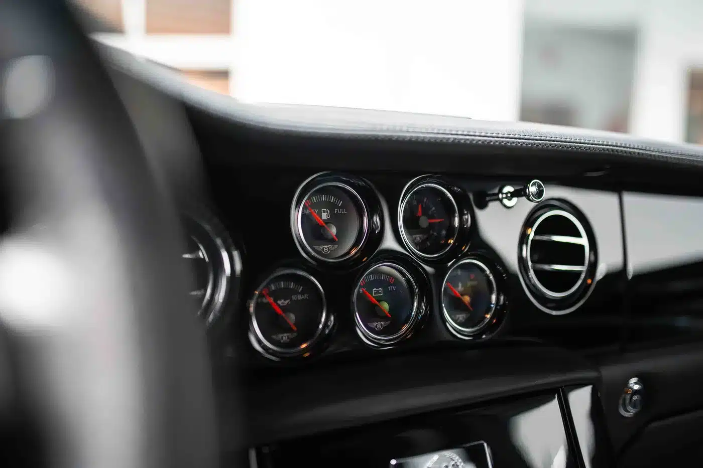 Detailaufnahme der analogen Rundinstrumente im Armaturenbrett eines Bentley Arnage T24 Mulliner, umgeben von glänzendem Leder und Chrom.