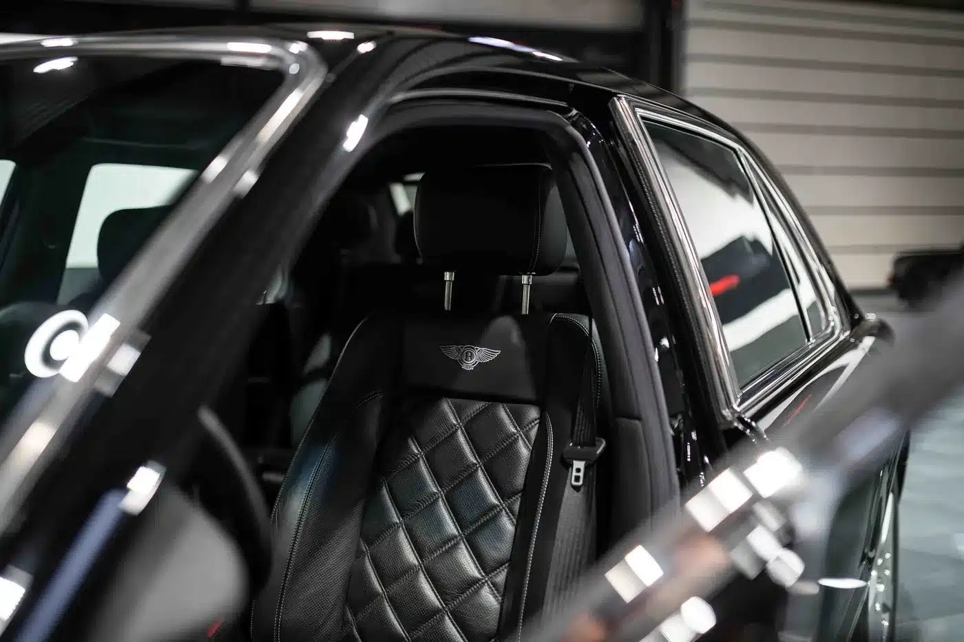 Luxuriöser schwarzer Ledersitz mit gestepptem Muster und Bentley-Logo im Innenraum eines Bentley Arnage T24 Mulliner