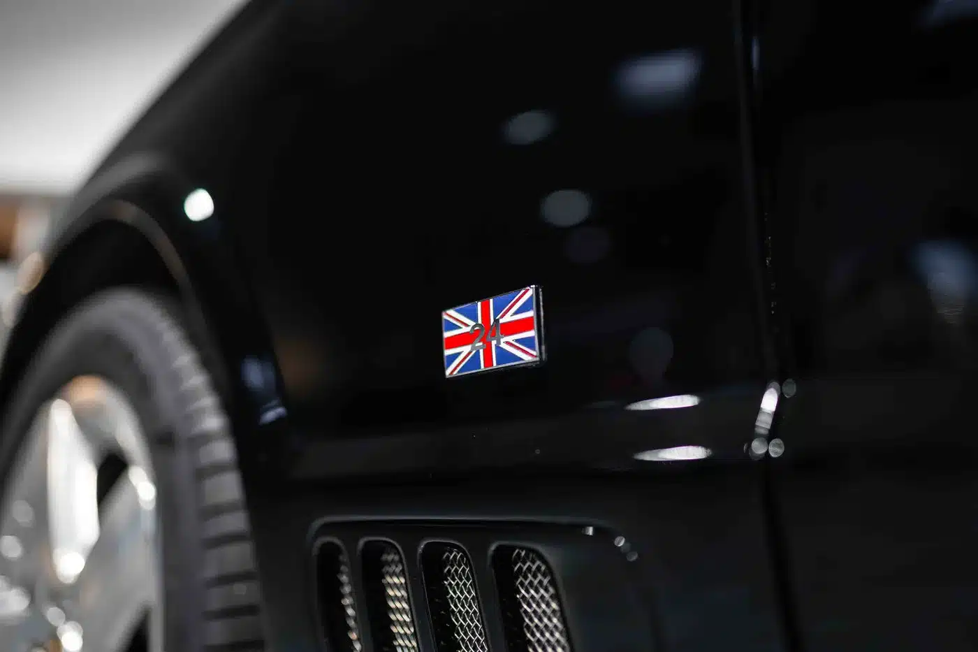 Union Jack Plakette mit roter '24' an einem schwarzen Bentley Arnage T24 Mulliner, Fokus auf Kotflügel und Detail