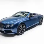 Blauer Bentley Continental GTC V8 S Cabriolet, Baujahr 2014, auf weißem Hintergrund.