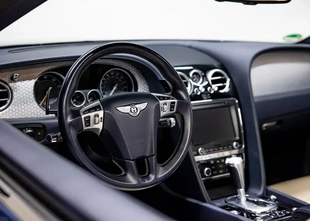 Lenkrad und Armaturenbrett eines Bentley Continental GTC V8 S von 2014 im luxuriösen Innenraum mit Leder und Chrom.