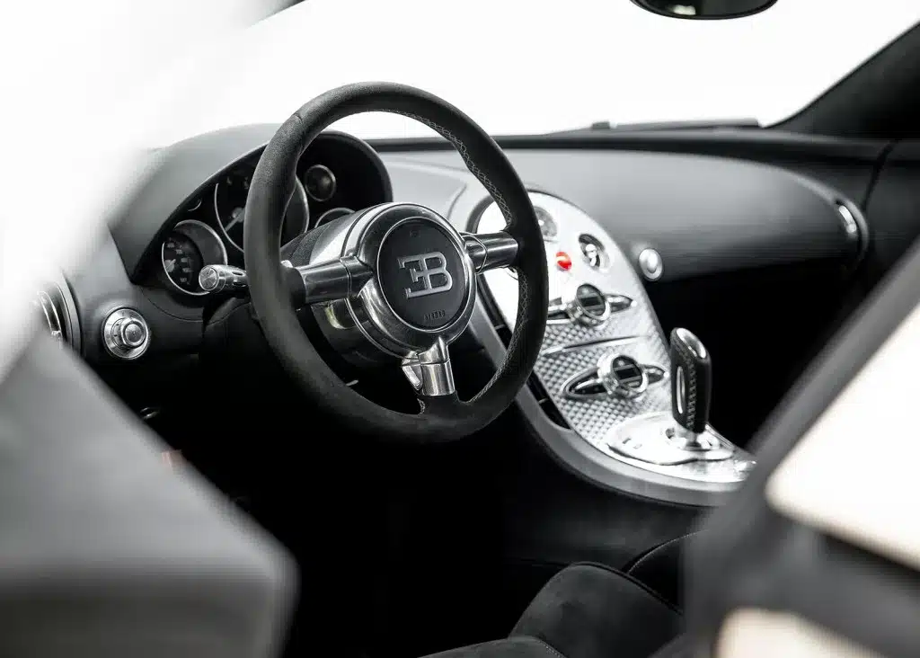 Luxuriöser Innenraum eines Bugatti Veyron 16.4 mit charakteristischem Lenkrad und Mittelkonsole.