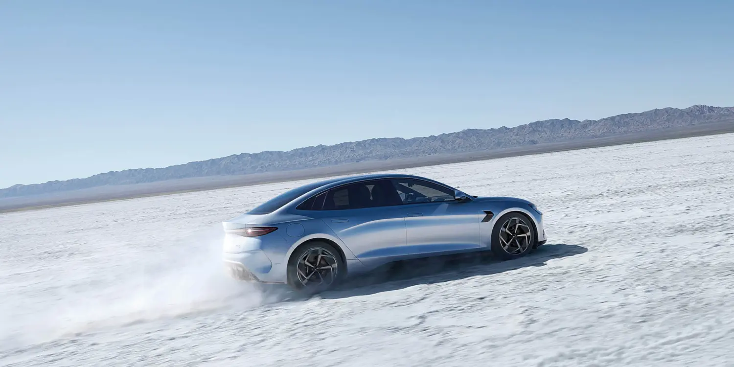 BYD Seal fährt auf einer offenen Salzebene, Seitenansicht der sportlichen Limousine.