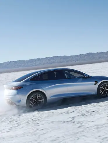 BYD Seal fährt auf einer offenen Salzebene, Seitenansicht der sportlichen Limousine.