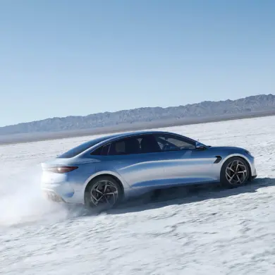 BYD Seal fährt auf einer offenen Salzebene, Seitenansicht der sportlichen Limousine.