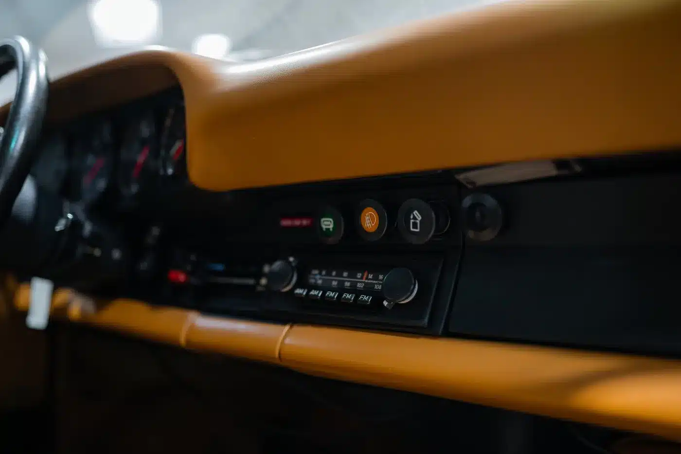 Nahaufnahme des Armaturenbretts und Bedienfelds eines klassischen Fahrzeugs mit Vintage-Radio und Schaltern