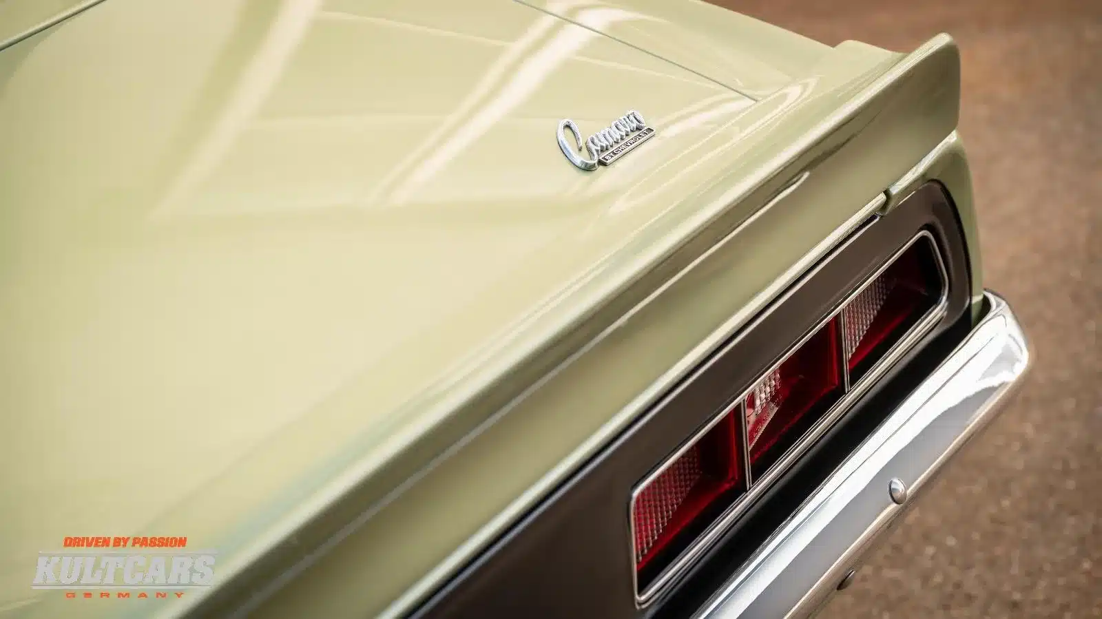 Detailansicht des Hecks und Camaro-Schriftzugs eines Chevrolet Camaro 350 V8, Baujahr 1969, in grüner Metallic-Lackierung.