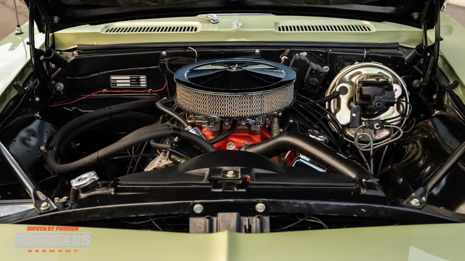 Offener Motorraum eines Chevrolet Camaro 350 V8 von 1969 mit großem Luftfilter und sichtbaren Technikelementen