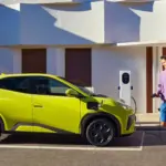 BYD Dolphin Surf Elektroauto in Gelb beim Ladevorgang an einer Wallbox vor einem modernen Gebäude.