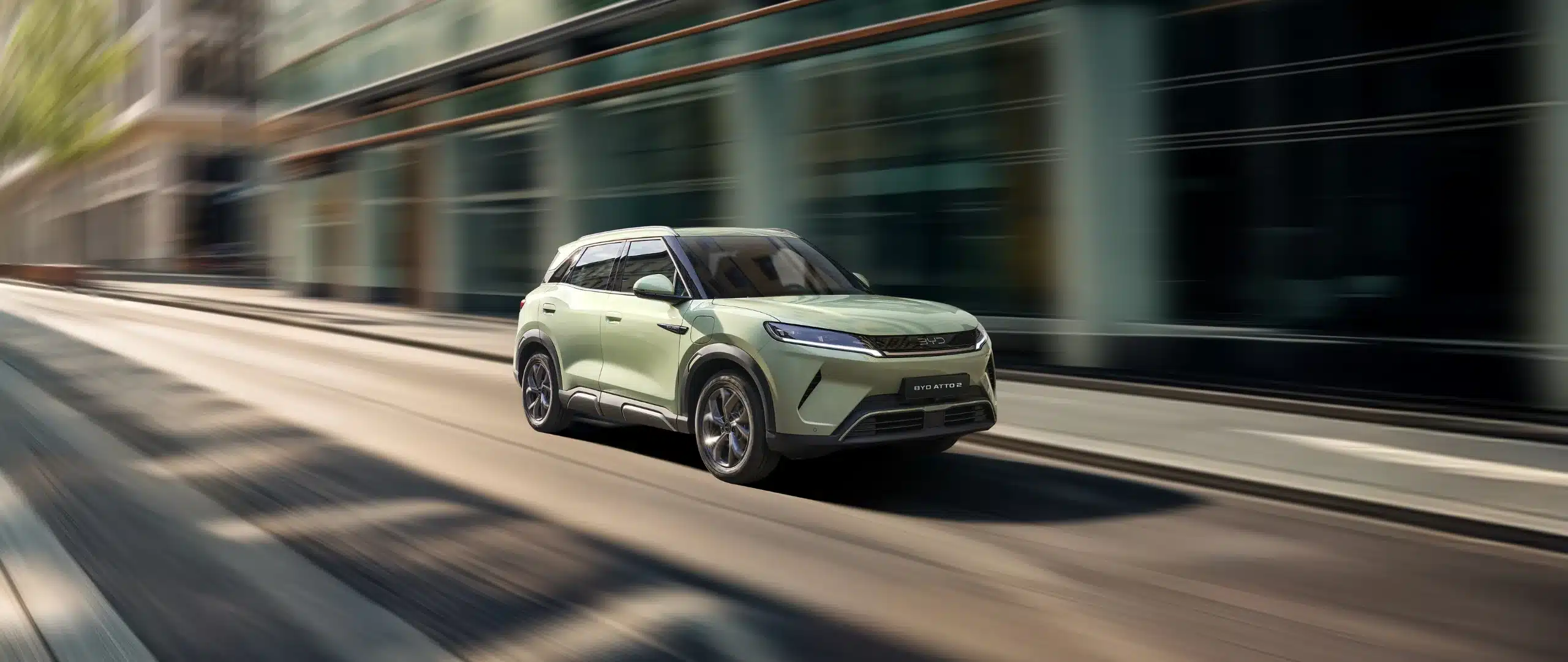 BYD ATTO 2 fährt als elektrischer Kompakt-SUV durch eine moderne Stadt