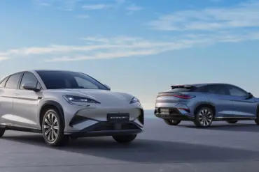 Zwei BYD SEALION 7 Elektro-SUVs stehen vor maritimer Kulisse auf einer Plattform, einer von vorn, einer von hinten.