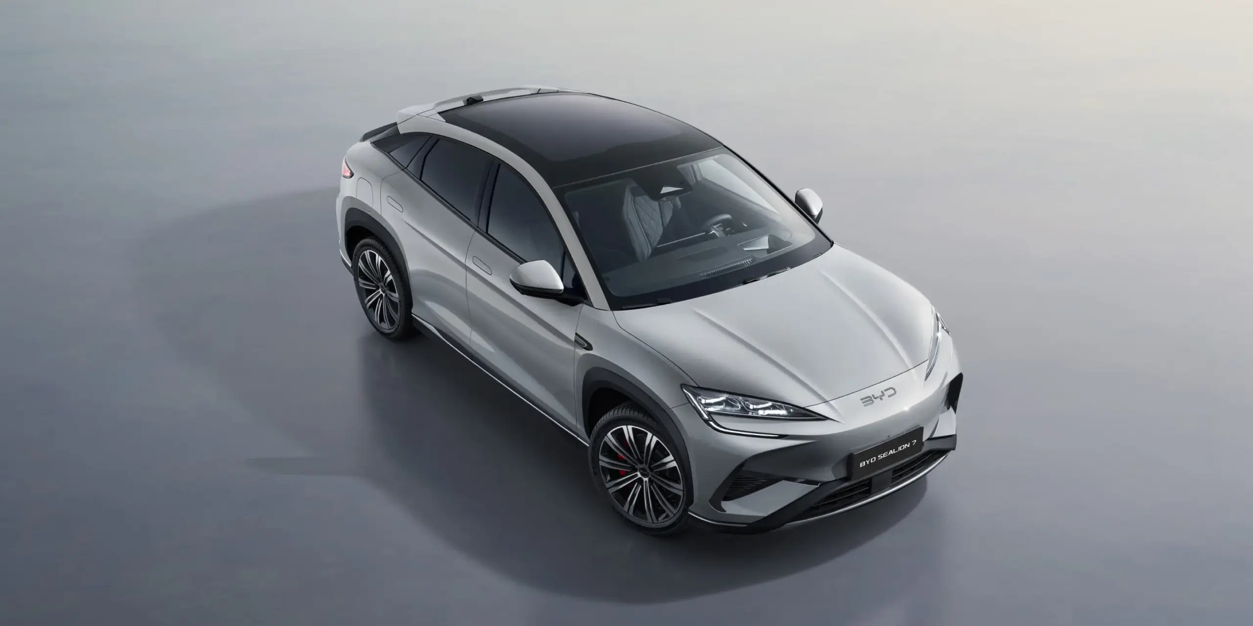 Der BYD SEALION 7 als weißes Elektro-SUV aus schräger Vogelperspektive mit Panoramadach.