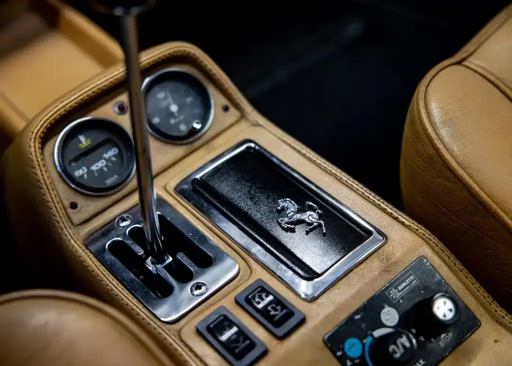 Mittelkonsole eines Ferrari 208 GTB mit Schalthebel, Instrumenten und Ferrari-Logo