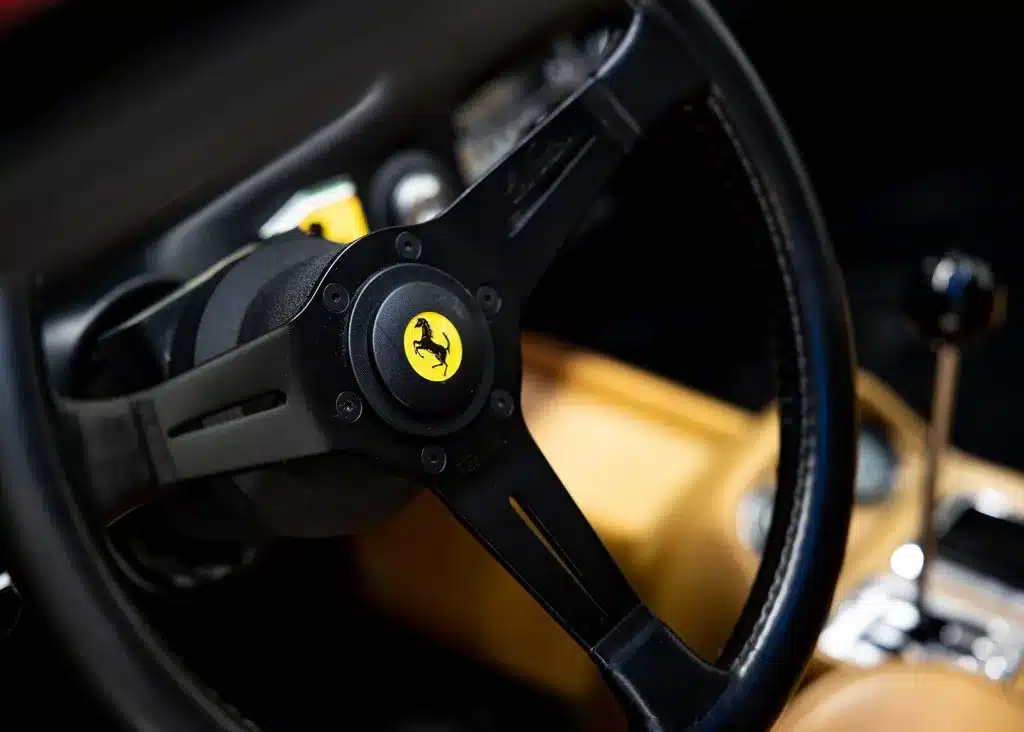 Ferrari-Lenkrad mit gelbem Emblem und Blick auf die Mittelkonsole im Interieur des 208 GTB.