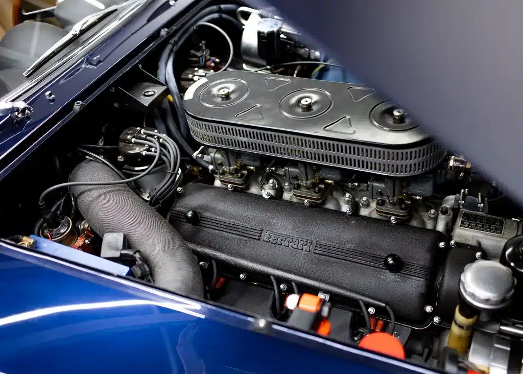 Motorraum eines Ferrari 250 GT Lusso mit sichtbarem Colombo-V12-Triebwerk und klassischer Ansaugbrücke