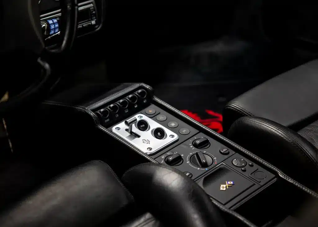Nahaufnahme der Mittelkonsole mit F1-Getriebesteuerung im Ferrari 355 F1 GTS, schwarzes Interieur