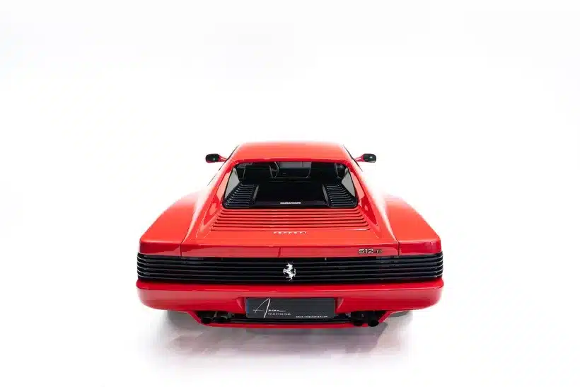 Heckansicht eines roten Ferrari 512 TR, Modelljahr 1992, mit typischer Coupé-Silhouette und schwarzen Lüftungslamellen.
