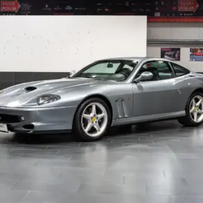 Silberner Ferrari 550 Maranello Handschalter, Frontmotor-V12-Coupé, ausgestellt in einer modernen Halle.