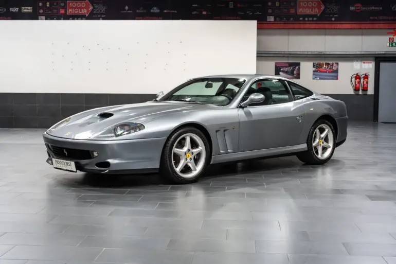 Silberner Ferrari 550 Maranello Handschalter, Frontmotor-V12-Coupé, ausgestellt in einer modernen Halle.