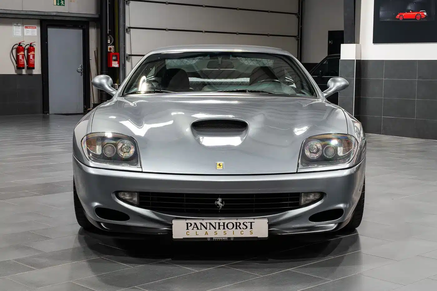 Ferrari 550 Maranello Handschalter in Silber, aufgenommen von vorne in einer Halle