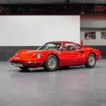 Ferrari Dino 246 GT Typ M von 1971 in Rot, seitlich von vorne fotografiert, in einer modernen Ausstellungshalle.