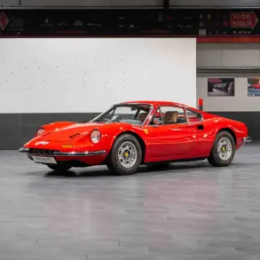 Ferrari Dino 246 GT Typ M von 1971 in Rot, seitlich von vorne fotografiert, in einer modernen Ausstellungshalle.