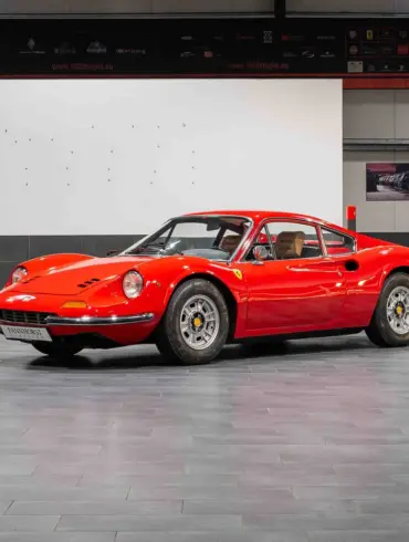 Ferrari Dino 246 GT Typ M von 1971 in Rot, seitlich von vorne fotografiert, in einer modernen Ausstellungshalle.
