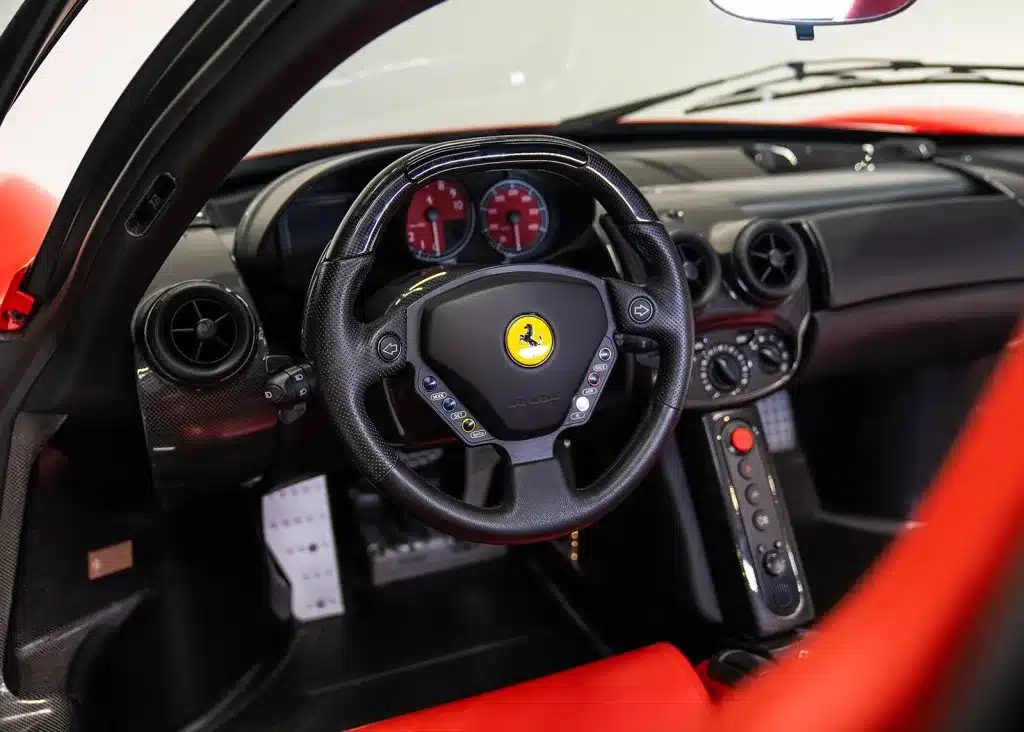 Innenansicht des Ferrari Enzo mit Blick auf Lenkrad, Armaturenbrett und Schalthebel.